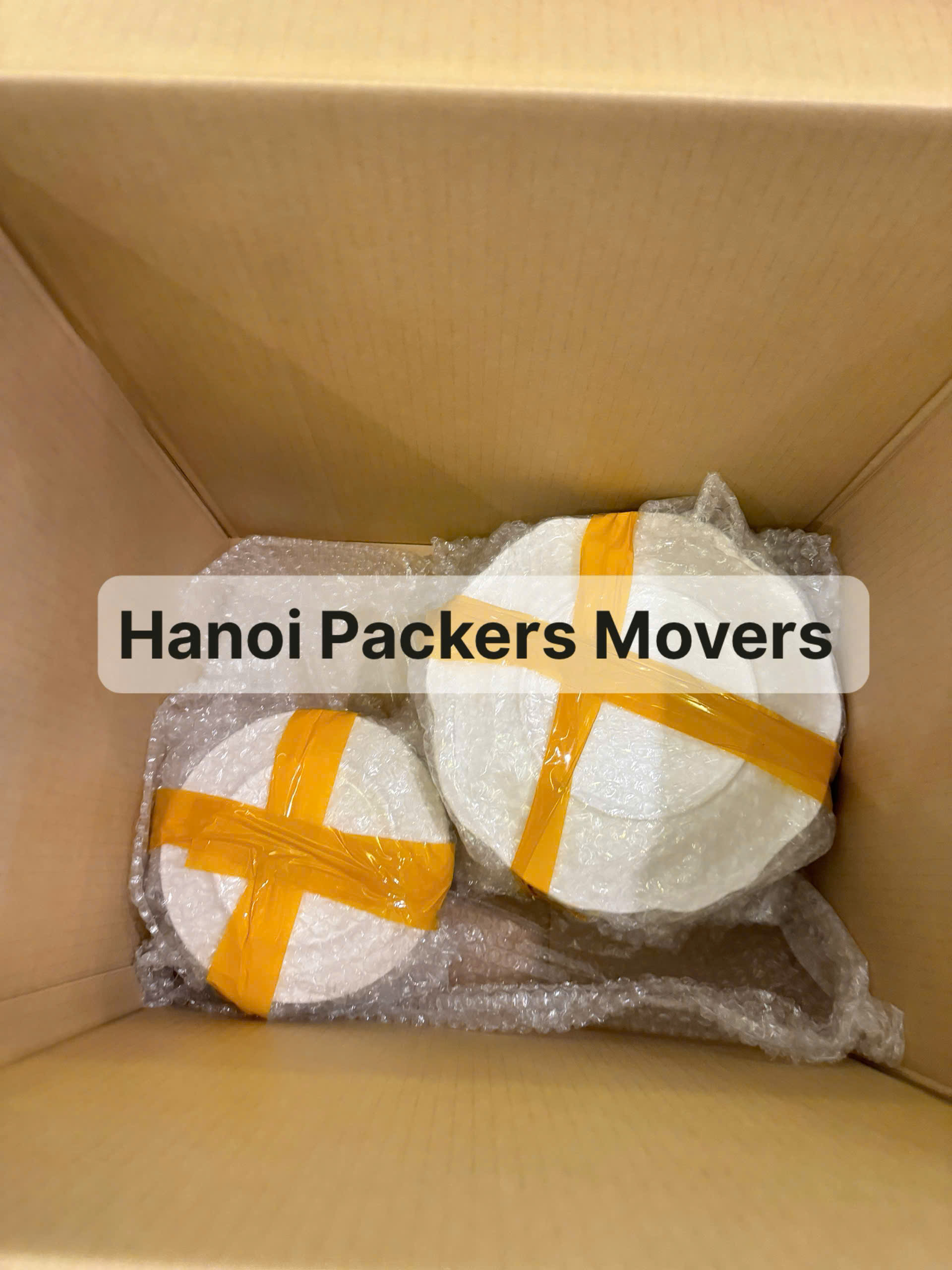 professional movers wrapping glassware and dishes for safe transport